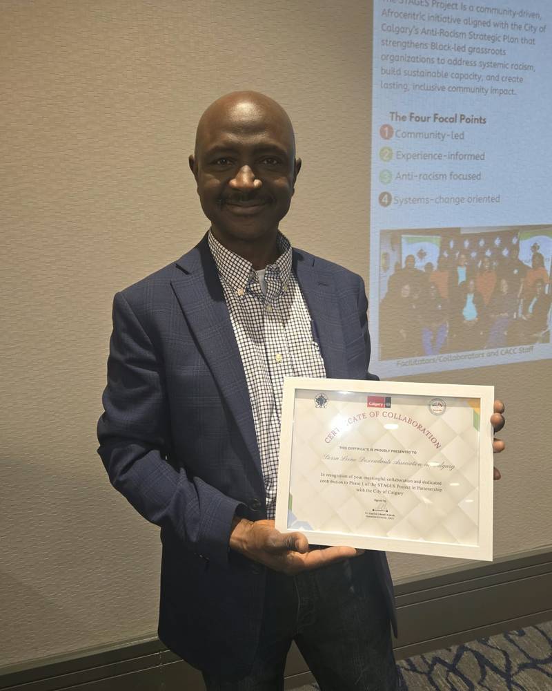 Abdullah Kamara holding a framed certificate of collaboration