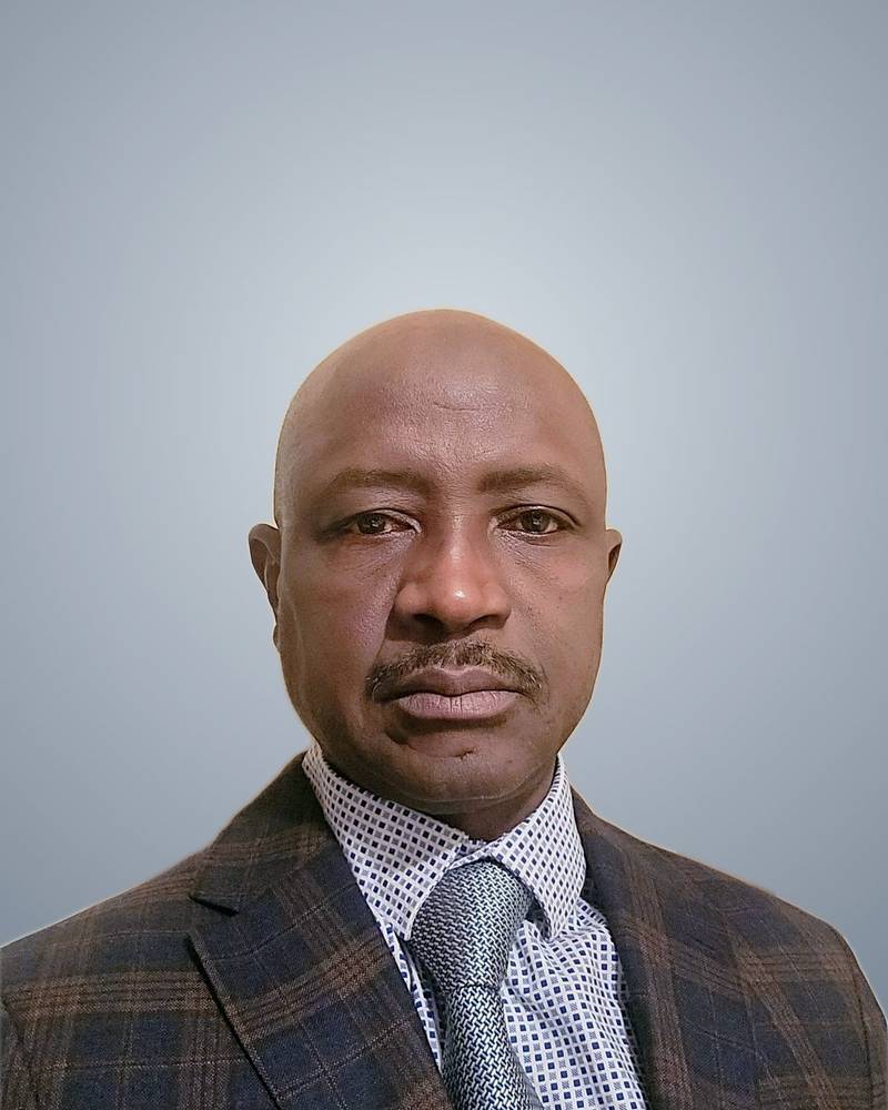 Abdullah Kamara, President of SALDAC, in a navy check jacket, patterned shirt and tie